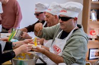 Uno de los participantes rellena el papel con la masa del sobao